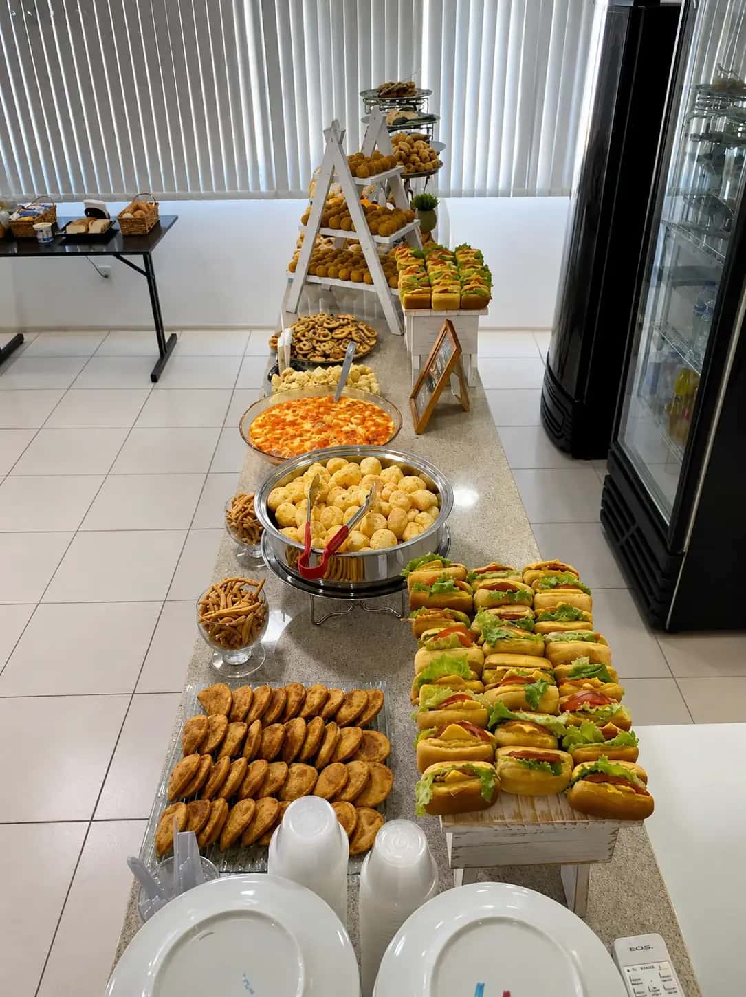 Buffet de brunch corporativo com salgados, sanduíches e doces para evento em Porto Alegre