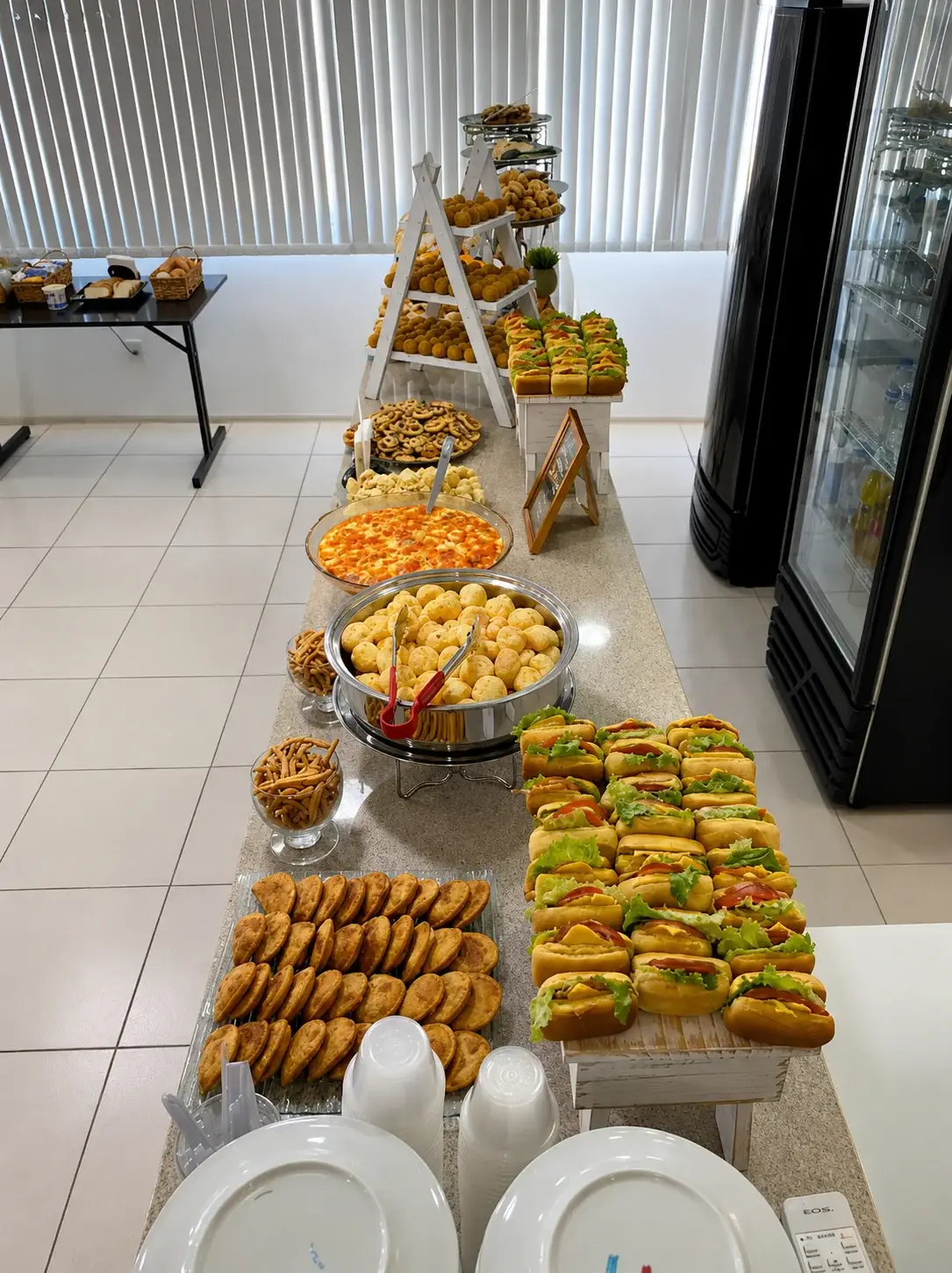 Buffet de brunch corporativo com salgados, sanduíches e doces para evento em Porto Alegre
