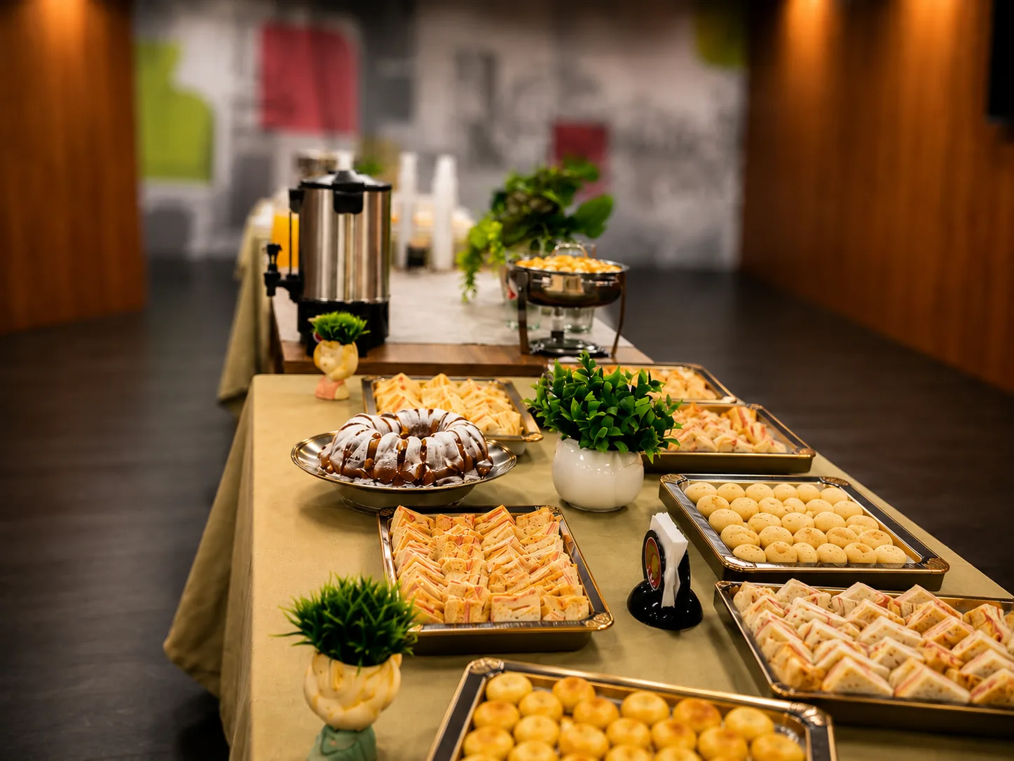 Mesa de coffee break corporativo Porto Sabor com café, bolo, salgados e doces para evento inclusivo