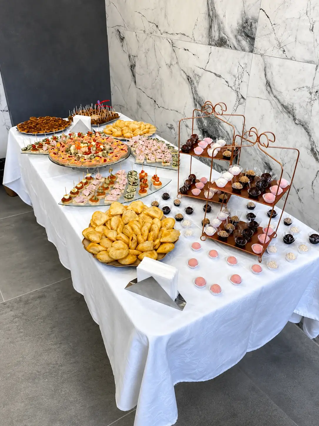 Mesa de coquetel corporativo com salgados finos e doces para evento em Porto Alegre