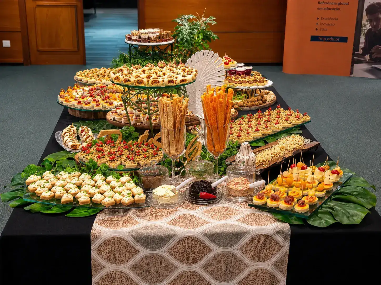 Mesa de salgados finos montada para evento corporativo — catering Porto Alegre