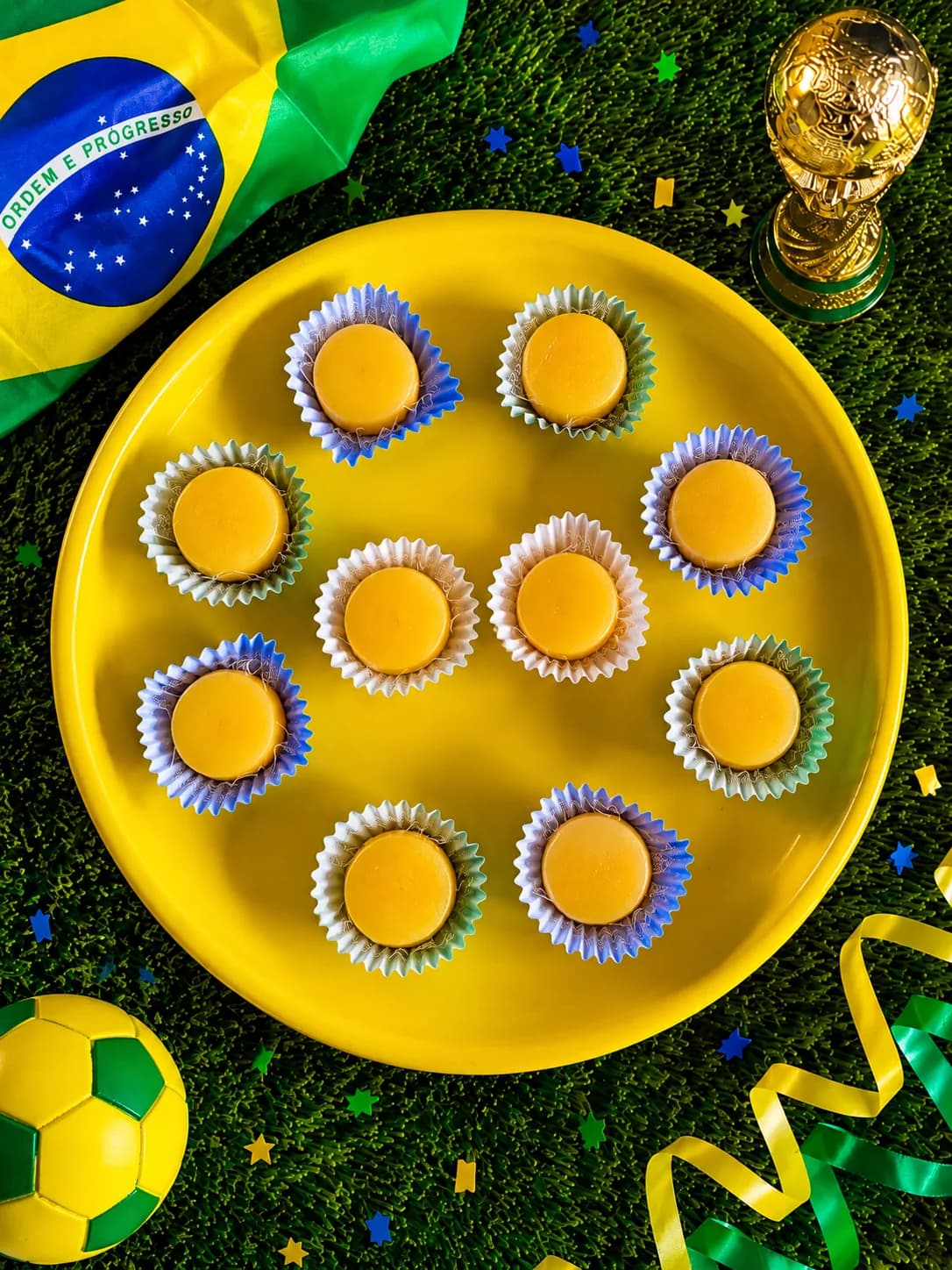 Brigadeiros decorados em bandeja amarela com tema de festa junina e Brasil.