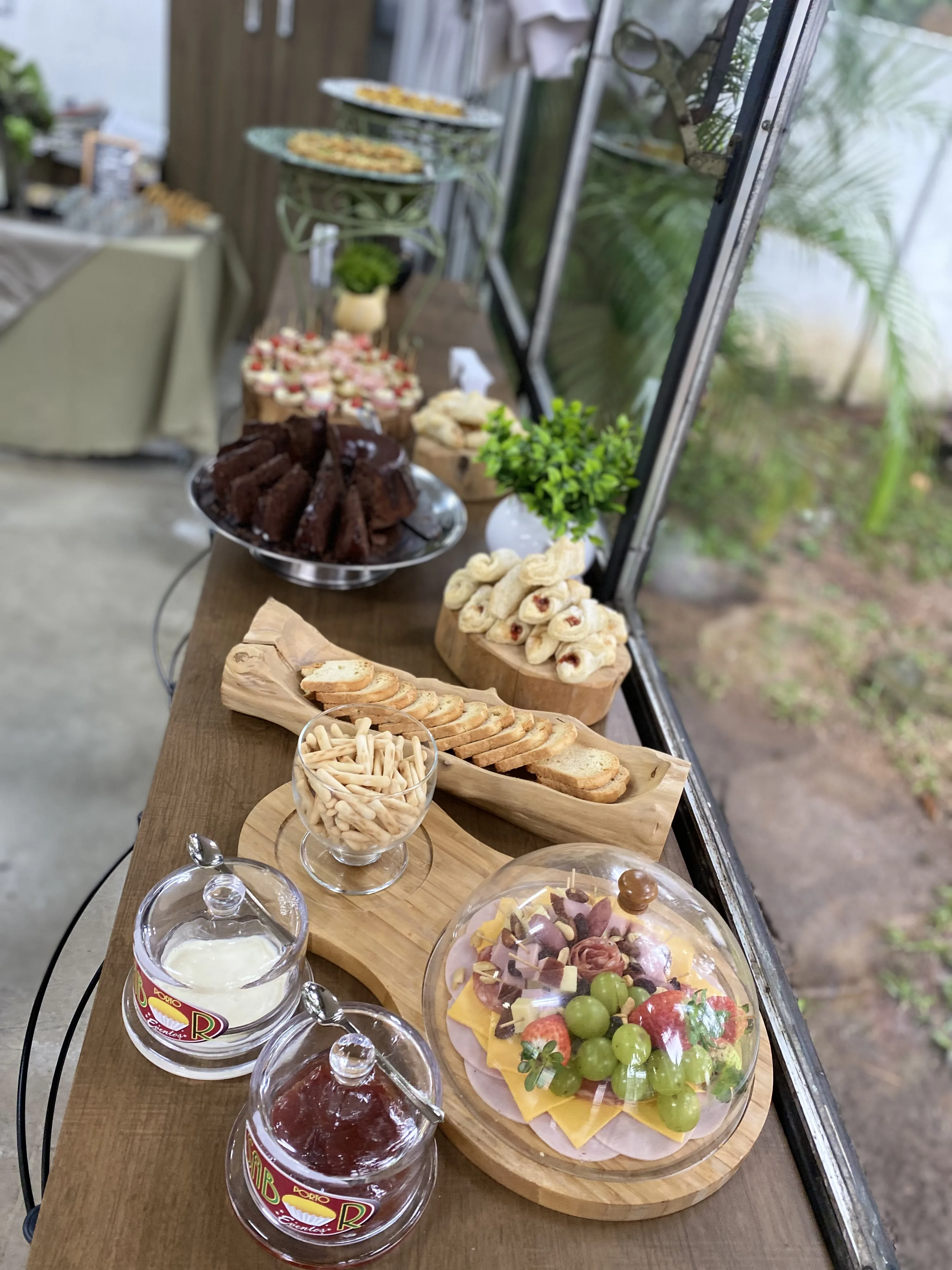 Mesa Porto Sabor com doces finos, frutas, chá e arranjos para evento.